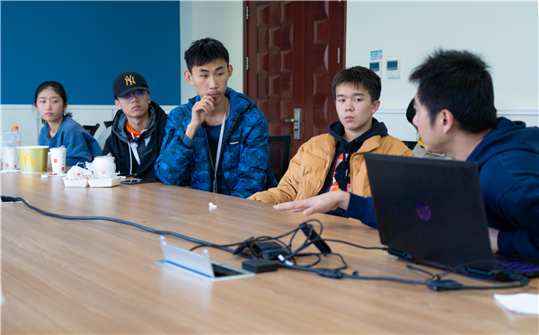 1640350732276807.jpg 圖三:秦威在與同學(xué)討論問題.jpg